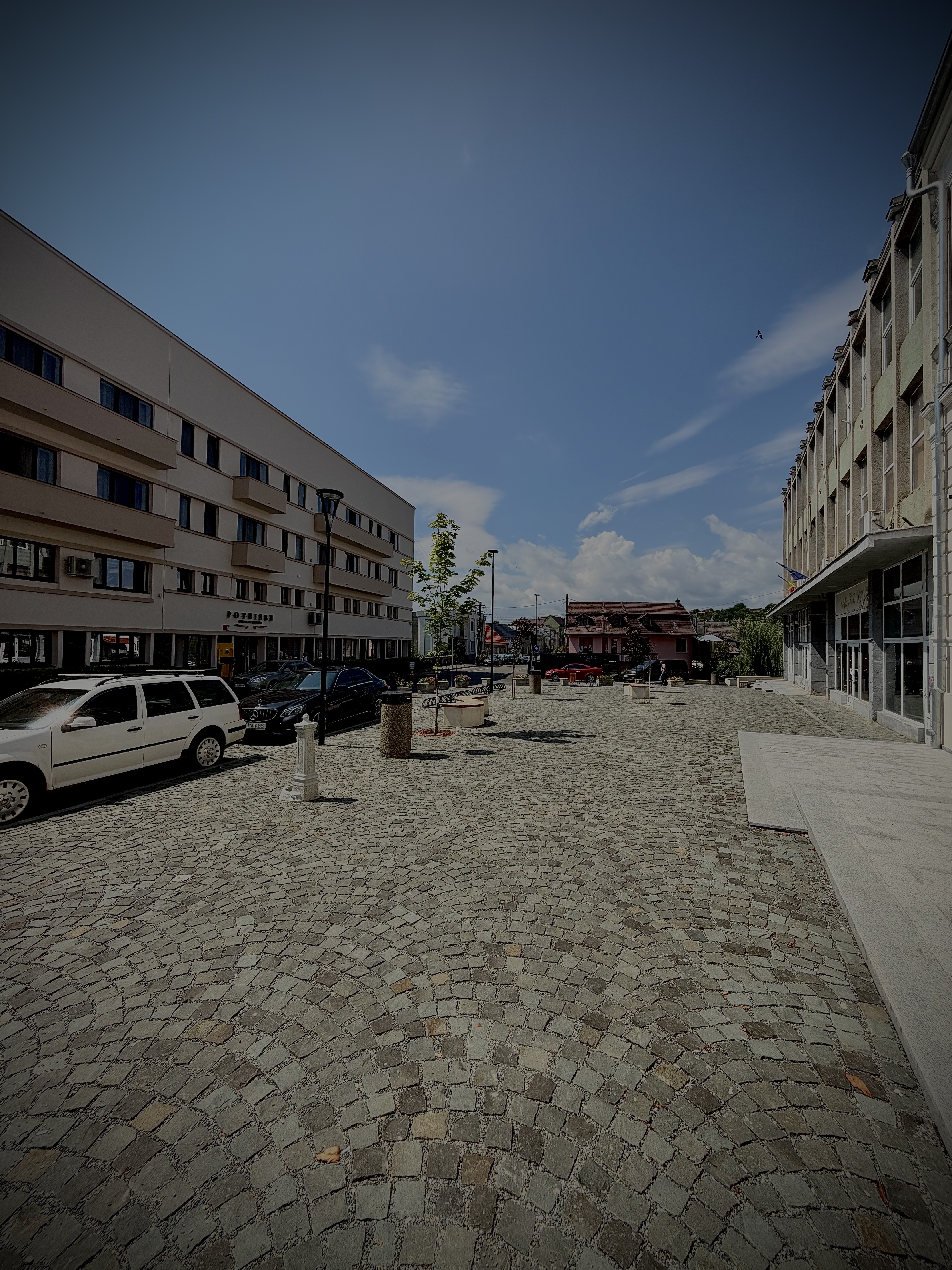 A paved street between apartment buildings, shot at a low angle