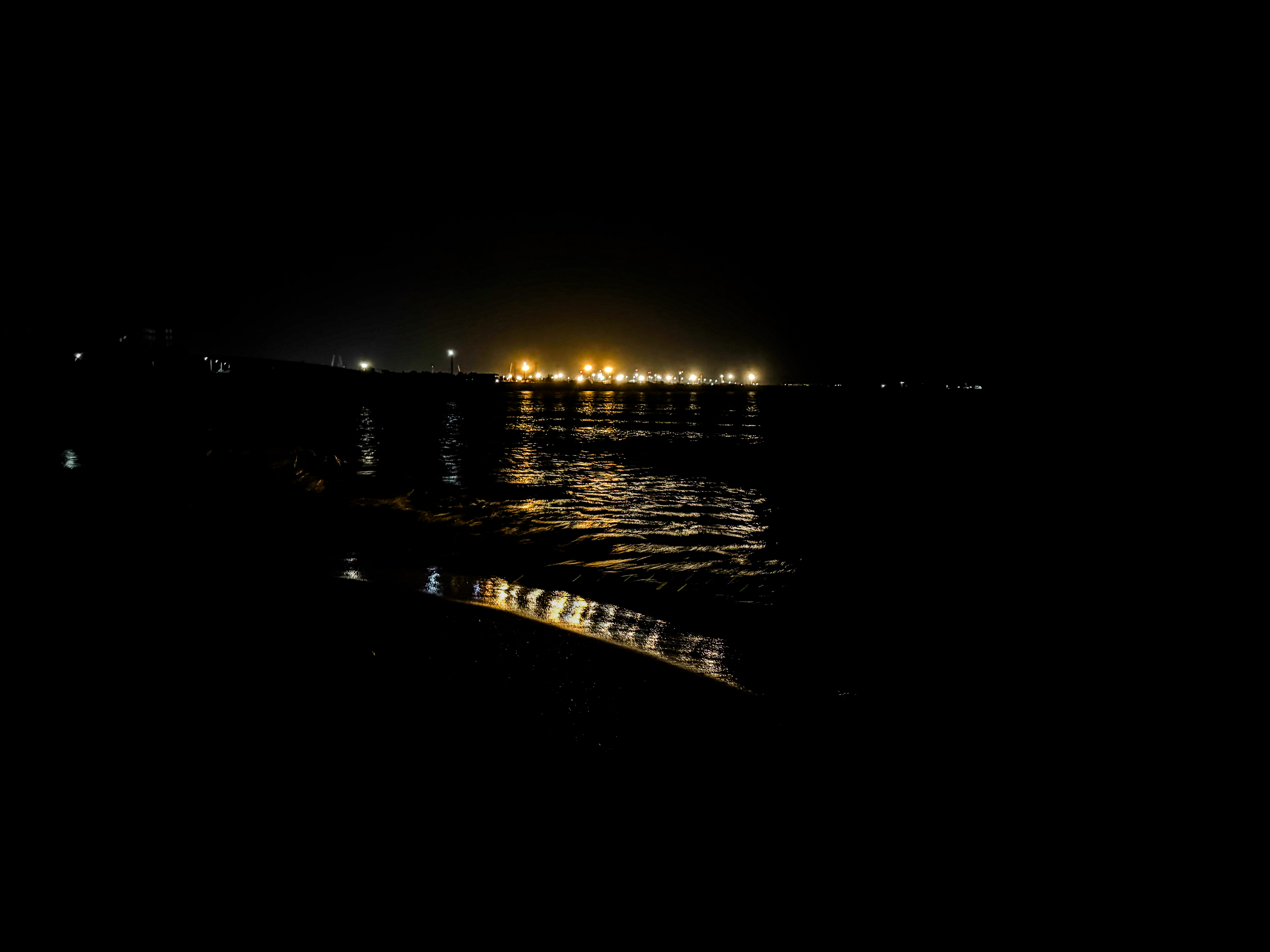Lights reflecting on wet sand at night